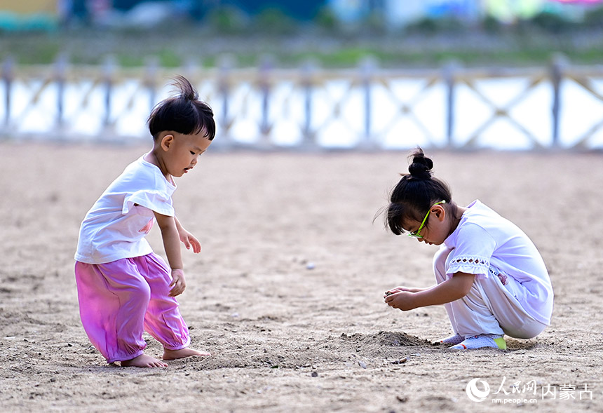 8月10日，小朋友在科尔沁右翼前旗科尔沁镇城中草原沙滩游戏区玩耍。王正摄