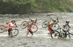 井冈山山地自行车挑战赛开赛 选手扛车涉水过赛道”