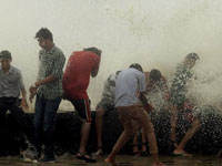 印度民众海边嬉水享受涨潮乐趣”