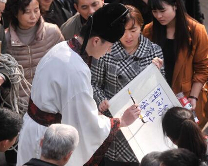 重庆年轻小伙穿汉服街头表演书法”
