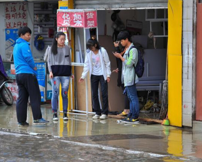 昆明一夜大雨部分路段积水严重 民众涉水出行”