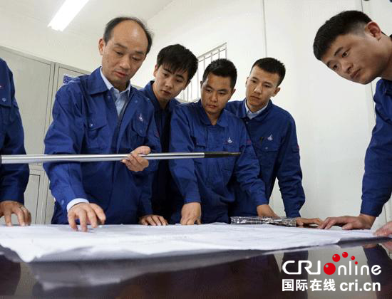 陈卫林为青年员工讲解加工流程。 摄影:刘维靖