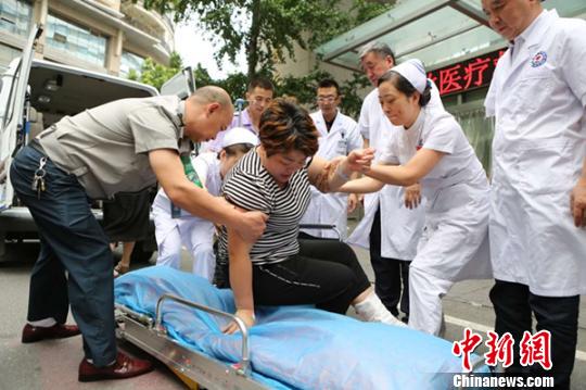 伤者在医护人员的陪护下转院。 陈冬冬 摄