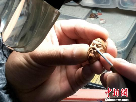 图为杨磊在雕刻人物面部形态。 张林虎 摄