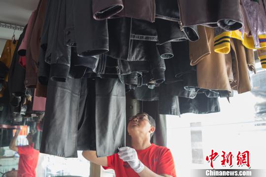 图为李文亮正在整理待处理的衣物。 陈冠言 摄