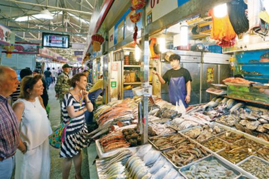 5月8日,在三源里市场72号商铺,外国顾客在选购海鲜产品。本文图片均为新华每日电讯记者 鞠焕宗 摄