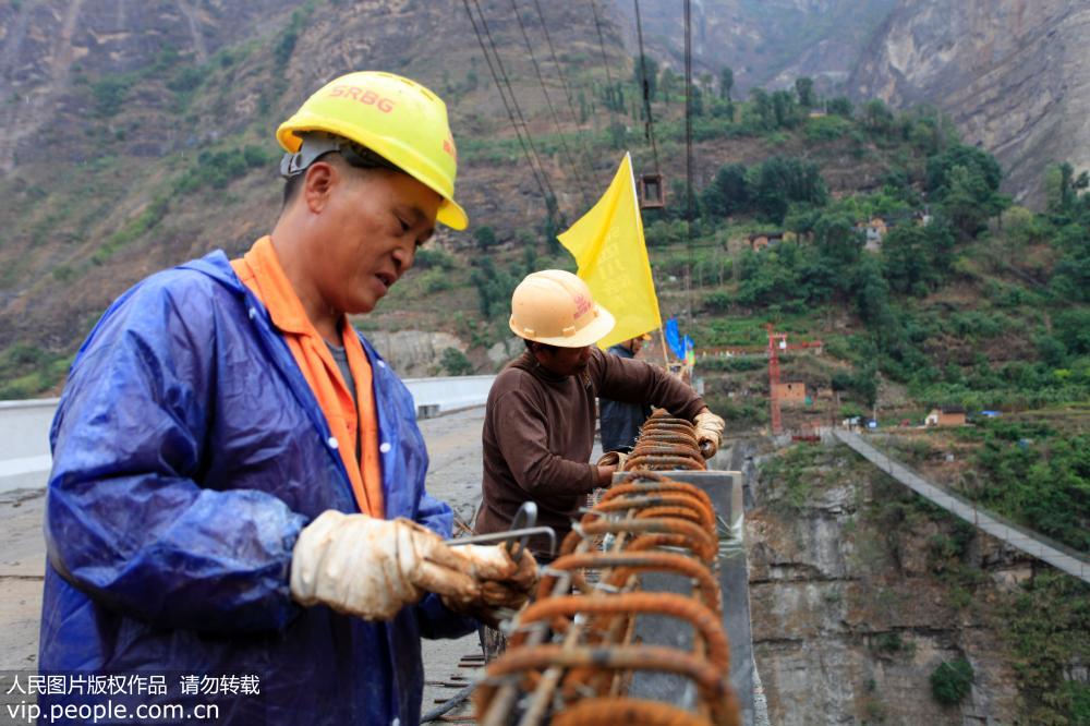 5月30日,在鹦哥大桥施工现场,施工人员在进行防护栏施工。