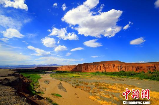 站在天山红河谷入口处的断崖边,可以清晰地看到远处的天山,天然的红土飘带,一簇簇的绿荫,坐落有致的农家院落,给人以强烈的视觉冲击。 李靖海 摄