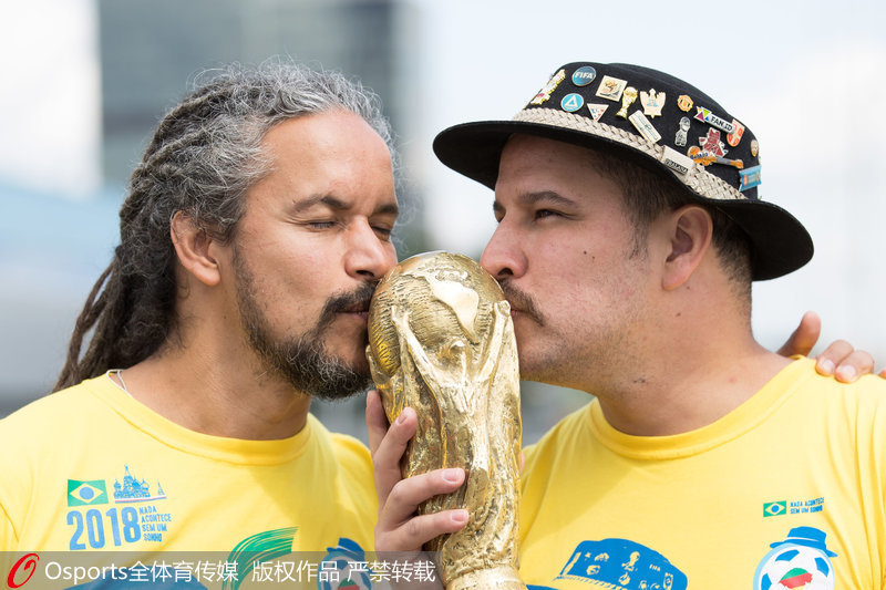 2018年6月14日,衣钵传承!金杯爷爷之子俄罗斯将再捧大力神杯为巴西呐喊助威。绰号“金杯爷爷”的克洛维斯·费尔南德斯被认为是巴西队的最佳第12人,自1990年起,他在每届大赛上都会亲临现场为巴西队加油助威。2015年,金杯爷爷不幸病逝,今年的俄罗斯世界杯,他的儿子将手捧大力神杯,继续为巴西队助威!