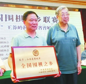 林建超(右)向冯志亮颁发“全国围棋之乡”牌匾