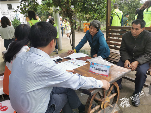 在木凉镇汉场坝村，志愿者们为村民提供社会救助咨询办理。华龙网-新重庆客户端 王钰 摄