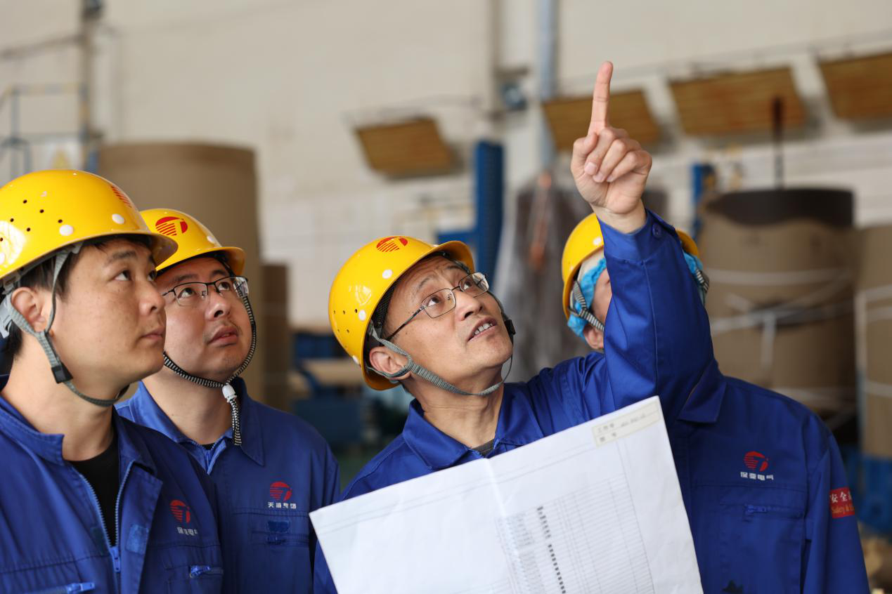 王树林正在给操作人员讲解整体线圈端部出线绝缘包扎注意事项