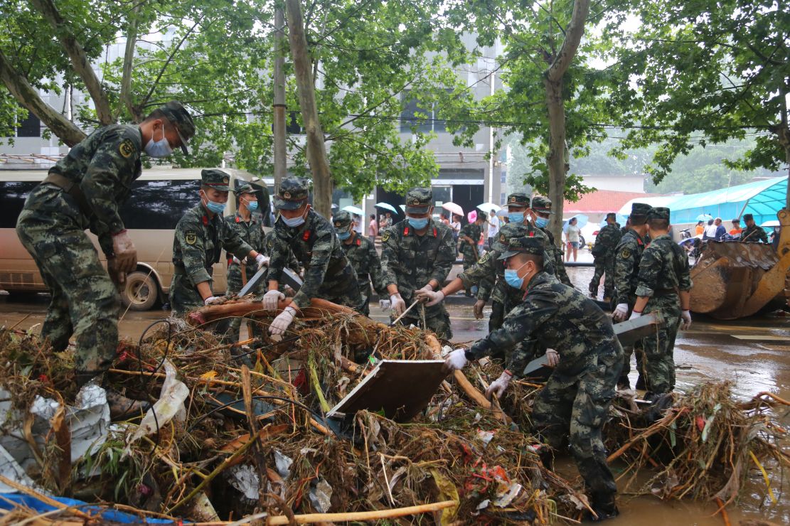 图为武警官兵去清理城市道路上的杂物。