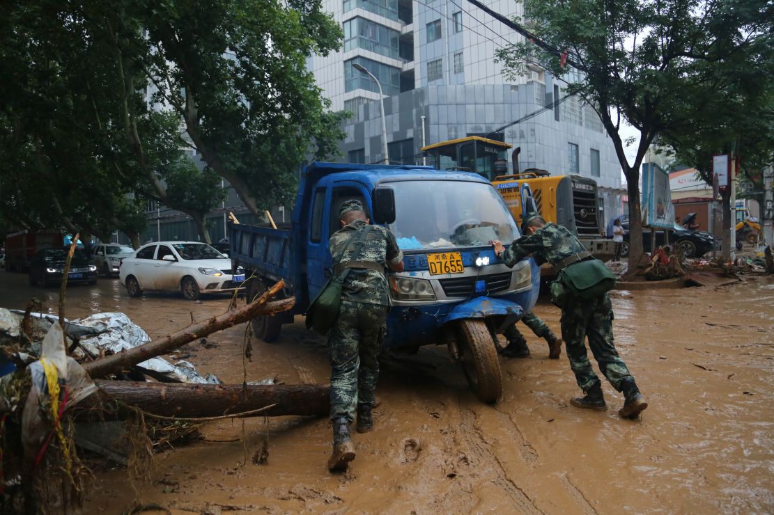 图为官兵挪动因洪水而报废的车辆。