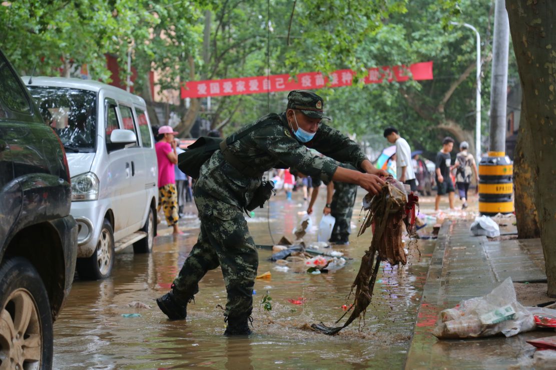 图为武警战士清理道路上的杂物。