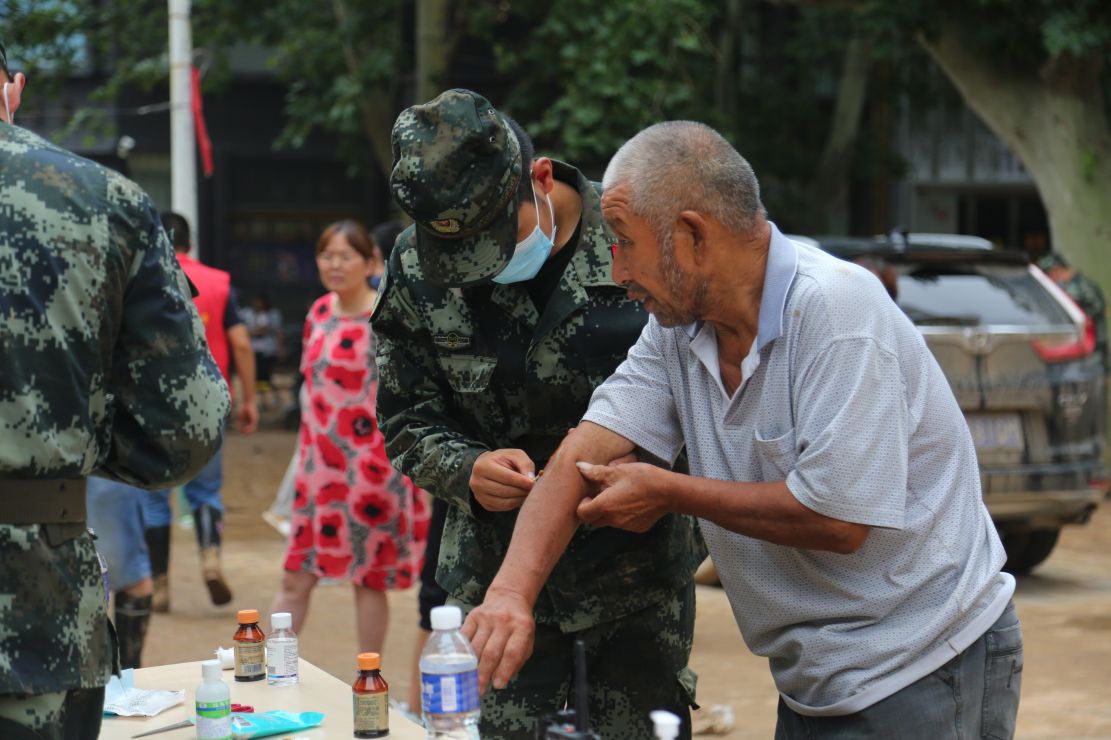 图为救治受伤的老人。