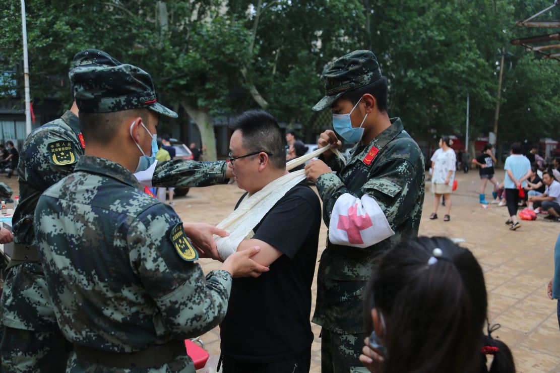 图为官兵救助当地受伤群众。