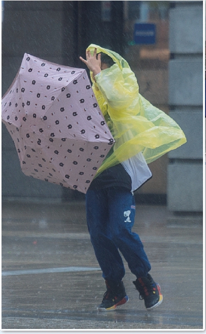 狂风暴雨让人凌乱不堪,雨伞和雨披几乎失去了作用.