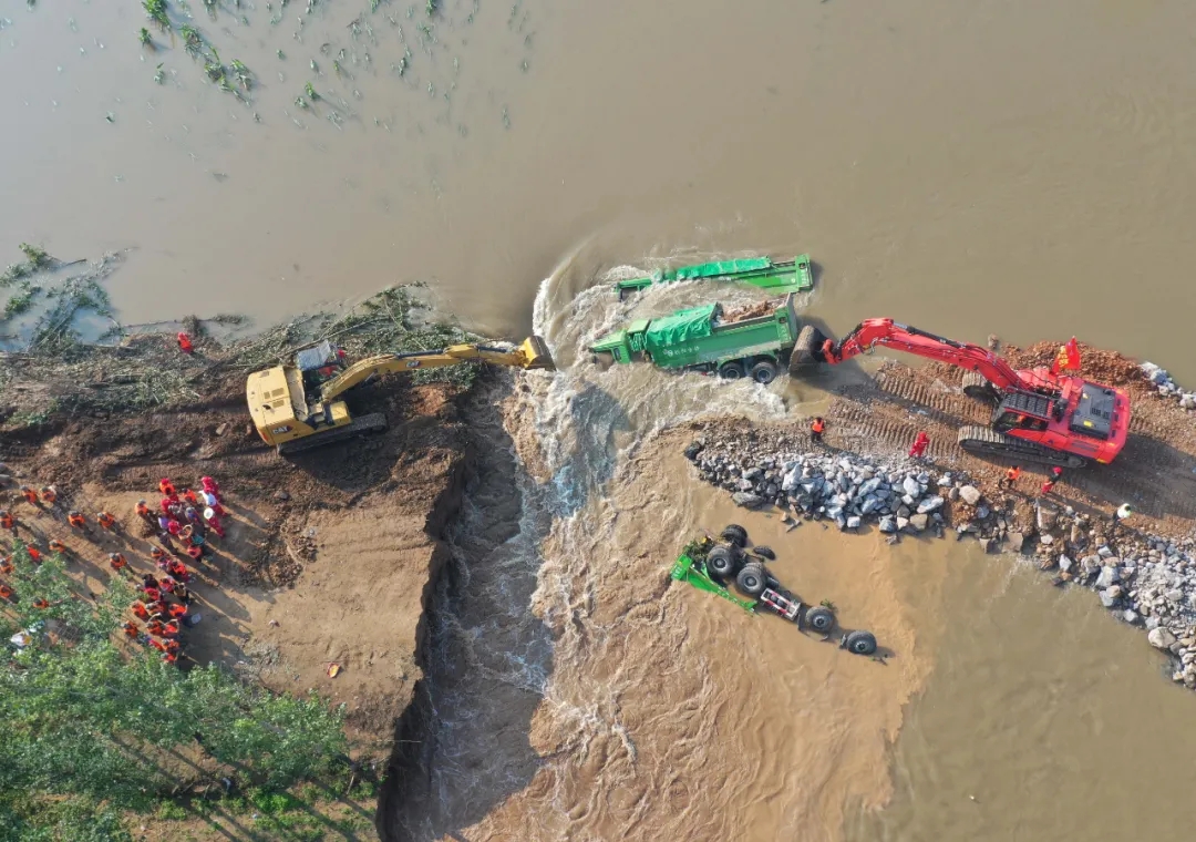 7月25日,满载石料的重型卡车被推入卫河鹤壁市浚县新镇镇彭村段的决口