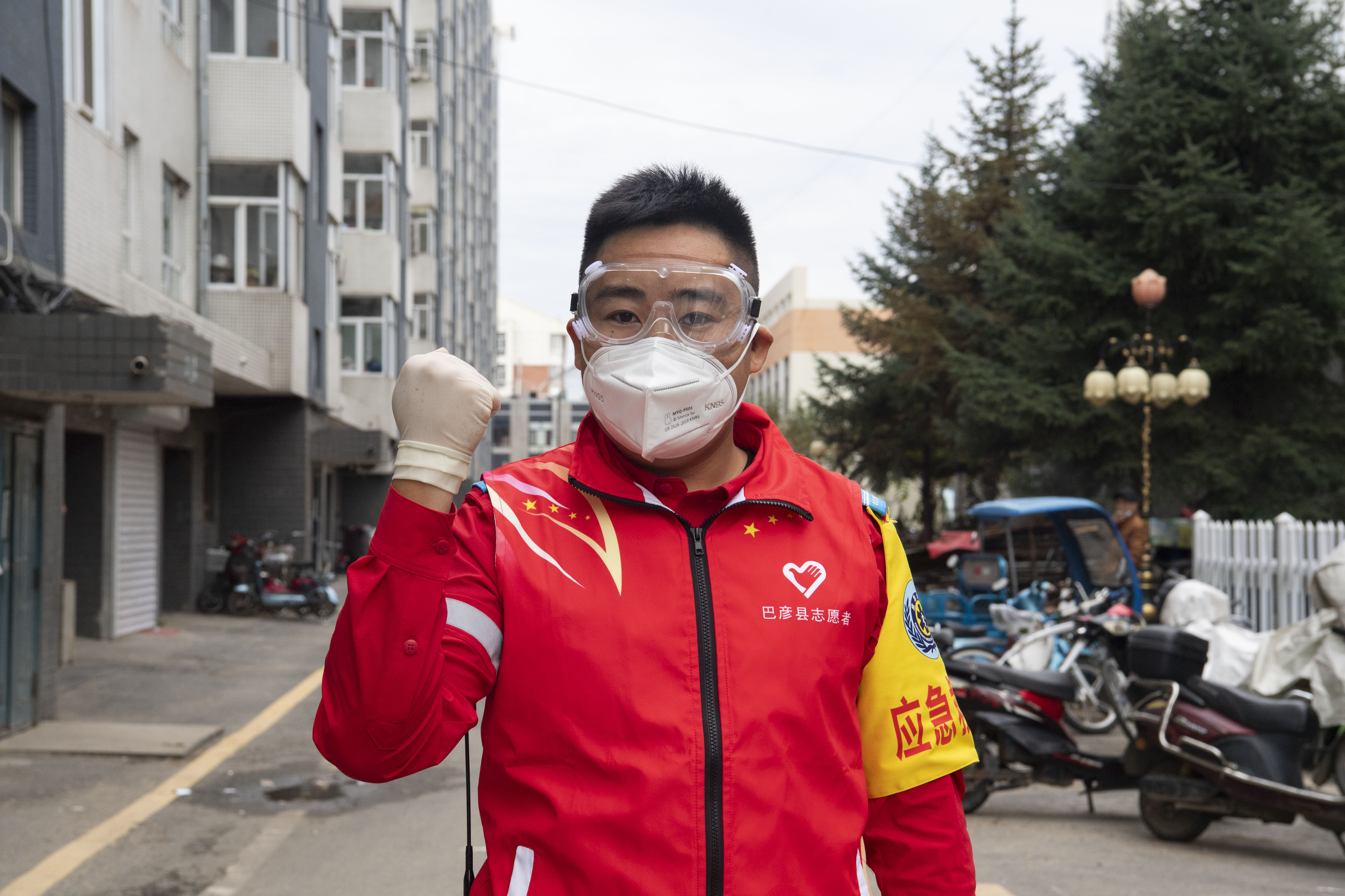 9月25日,在哈尔滨市巴彦县一小区,志愿者张尚方比手势鼓劲加油.