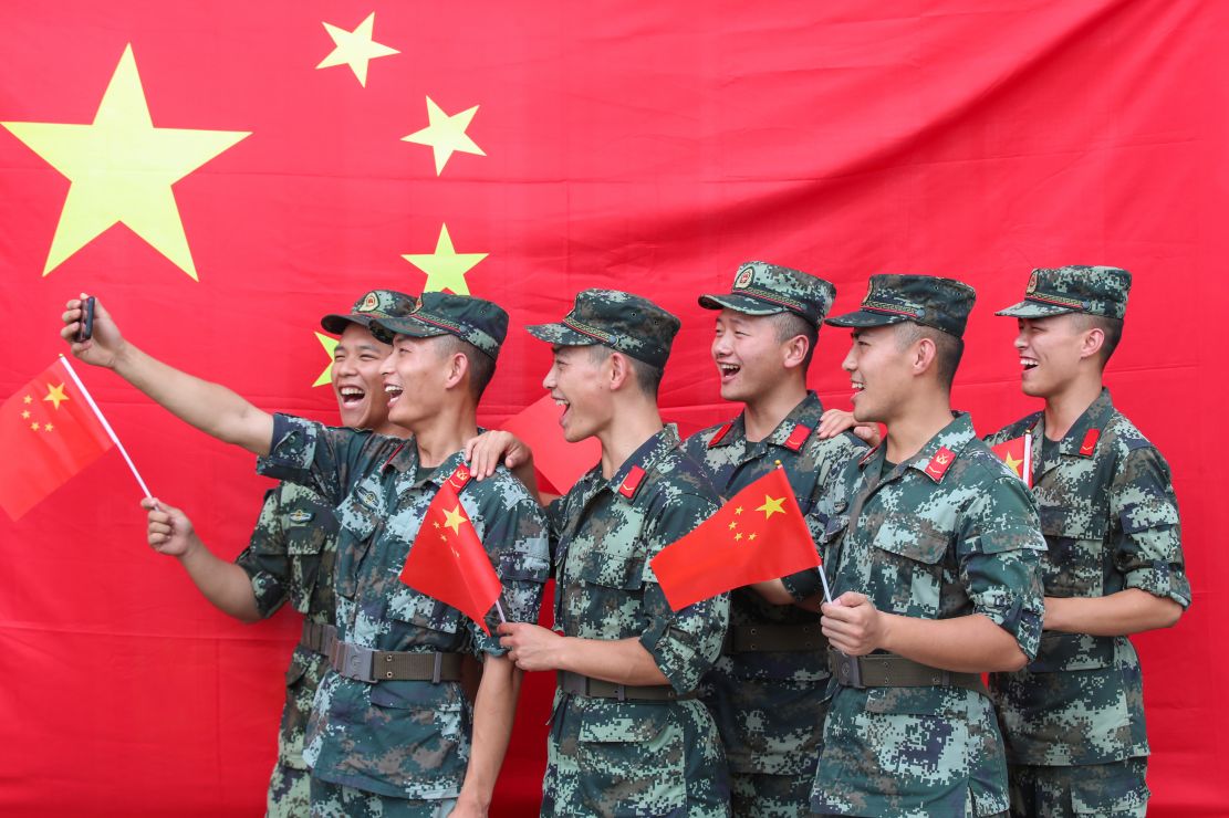 官兵们通过与国旗同框合影,重温军人誓词,《我和我的祖国》歌曲快闪等