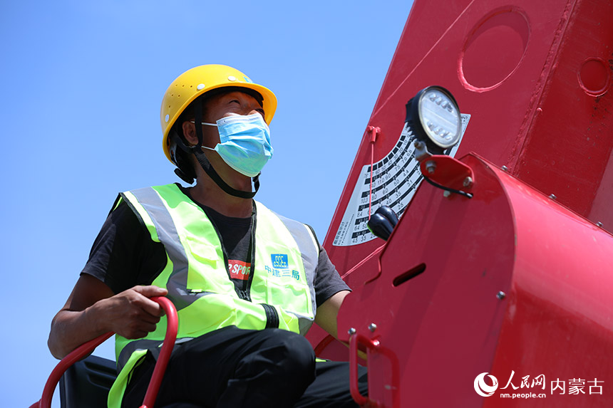 呼和浩特建设项目工地，中建三局的施工人员在操作随车吊。项目部制定了错时施工措施，确保高温天气下工人安全生产。人民网 李睿摄