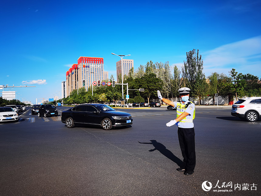 呼和浩特市赛罕区敕勒川大街与前达门路交叉路口，呼和浩特市公安局交通管理支队民警高温下正在指挥疏导交通。人民网 李睿摄