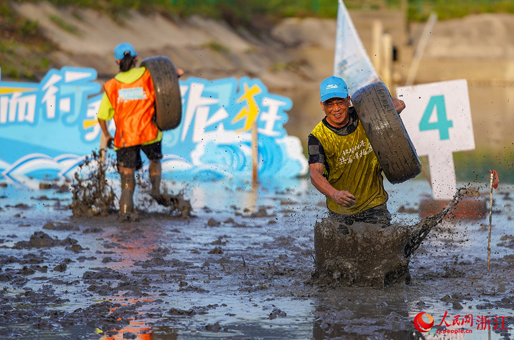 参赛选手在滩涂上进行滩涂搬物项目的比赛。人民网 章勇涛摄