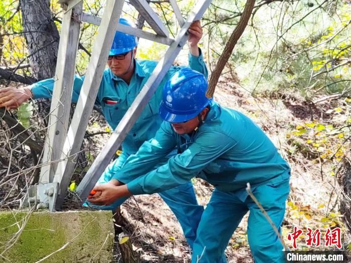 巡检人员正在为山上的杆塔消除缺陷。　国网山西省电力公司供图