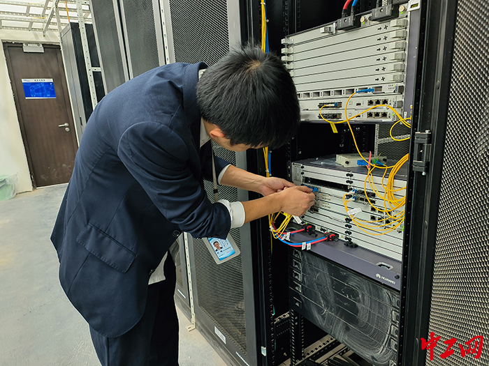 （摄影：冯鑫）为了精准测量每个弱电间各运营商的设备数量以及光纤长度占比，田曦进入综合管廊内仔细测量各运营商的光纤长度