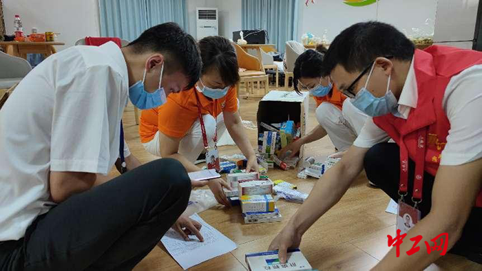 1谢丹和其他志愿者一起分发常规药品，每个人都在仔细核对各项表格，避免出现工作纰漏。尽管每个人都是蹲着分拣药品，可每一个人都是我们心中“最美的太阳”，照亮了每一个防控期间