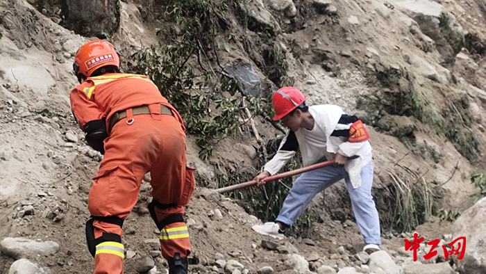 2抗震突击队队长杨涛与甘孜州森林消防支队雅江大队历时一个半小时抢通磨子沟村出村道路，为伤者抢通生命通道。