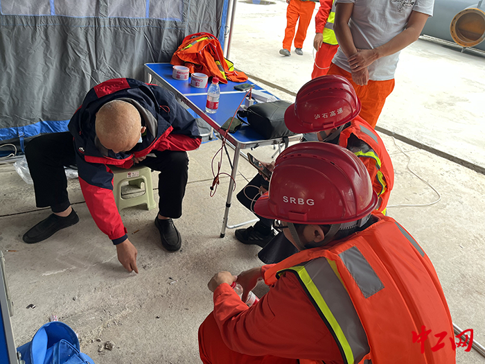 侯朝银（左一）在临时指挥部与队友讨论省道S217幸福村抢险点位登陆方案