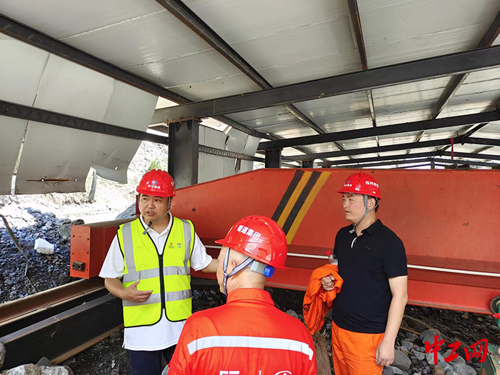 1聂东（左一）在湾东村与队员商讨临时车行栈桥搭建方案。