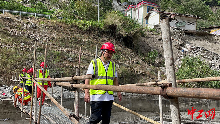 2湾东村入村“唯一通道”人行栈桥成功搭建后，聂东第一个上桥，亲身验收栈桥是否具备通行条件