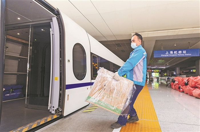 正文图为11月1日,在上海虹桥站,铁路工作人员将货物搬到g1373次列车上