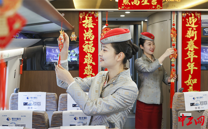 日前，青岛段高铁上，乘务员正在布置车厢新春装饰。翟祚珩摄