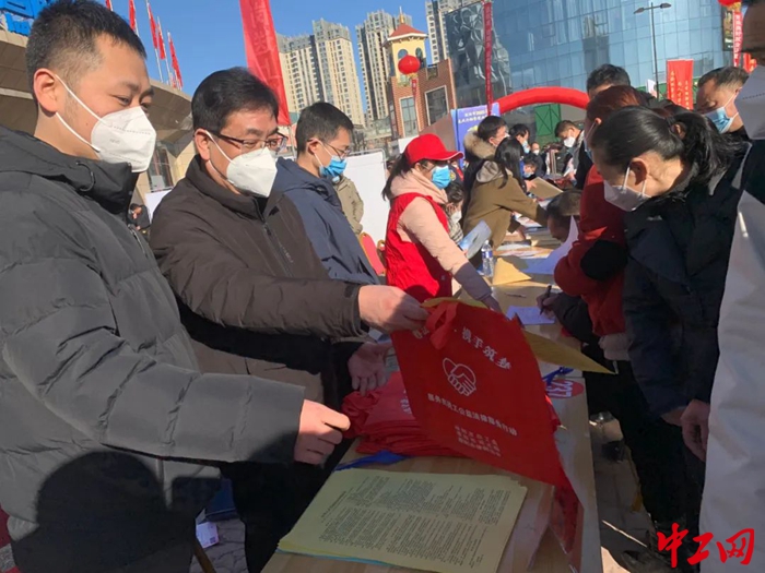 1 活动现场，法律援助工作人员发放宣传彩页和宣传袋。（濮阳市总工会 供图）