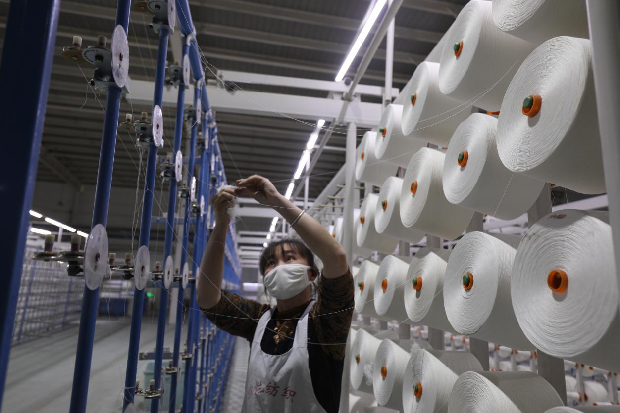 市绚烂纺织有限公司纺织车间,自动化大型设备不停运转,从纺纱,整经