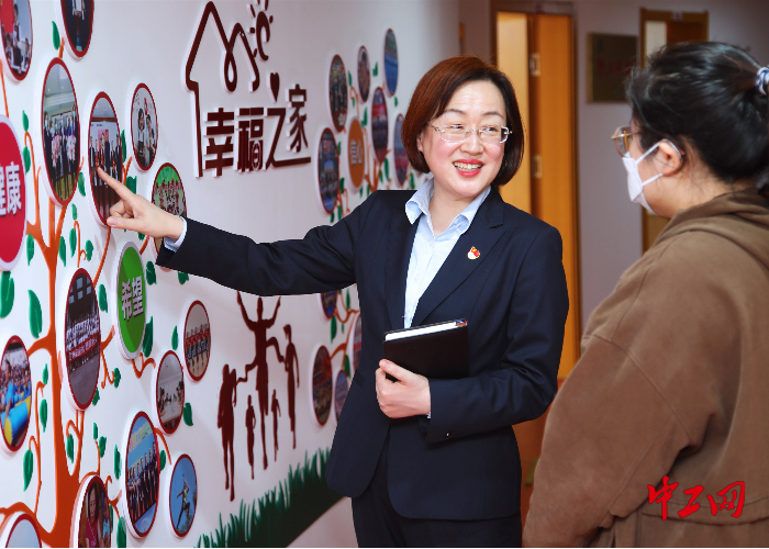 邹艳在和女职工分享企业职工之家活动展示墙上的精彩瞬间  威海市总工会提供