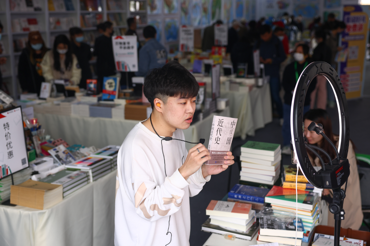 中工网>文娱>正文4月14日,北京朝阳公园内,市民正在北京书市选购图书.