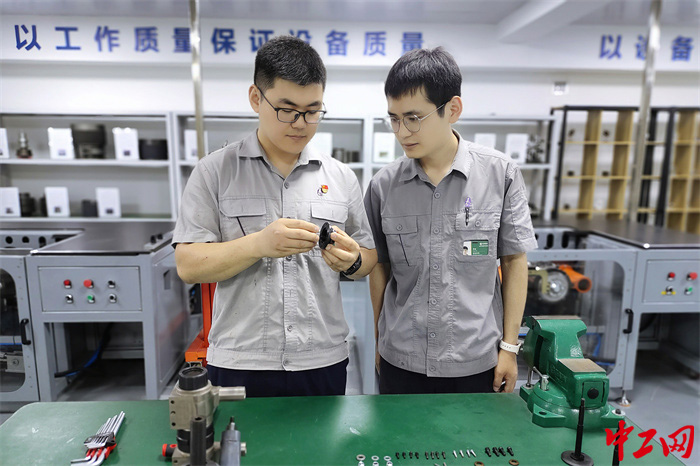 王凯鹏在给青年职工讲解设备拆装技巧。  魏好  摄