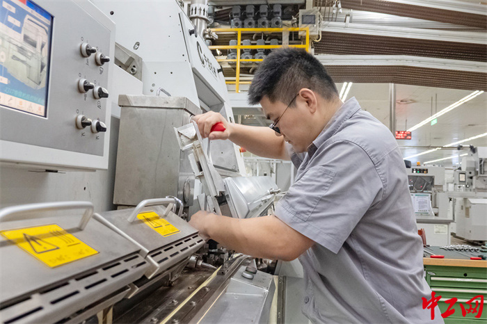 王凯鹏在调整卷烟机烟舌支座。  冀春晓  摄