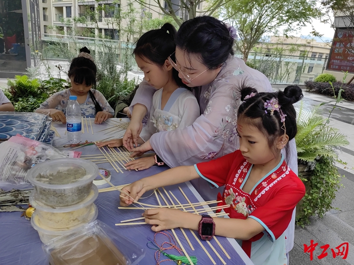 6月1日，项目工会工作人员教小朋友们制作竹编龙舟。冉宇 摄