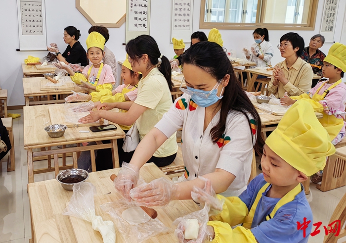 1.6月3日，在蛋糕烘焙师的指导示范下，家长们带着孩子开始制作蛋糕。（周口市总工会 供图）