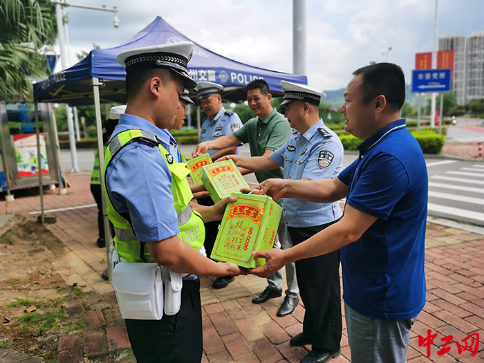柳东新区（高新区）总工会主席李慕江（右一）向酷暑下坚守岗位的交警队员送上清凉慰问品 摄影 柯宇