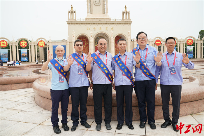 参会人员在北京展览馆外合影留念。中工网记者王鑫 摄