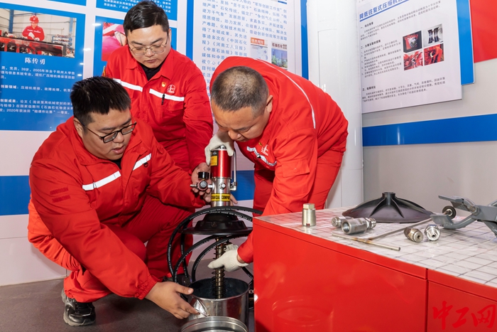 王军华为创新工作室里的徒弟们讲解。（王威 摄）