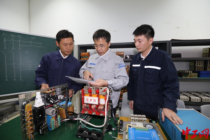 河南省工会十六大代表、全国劳动模范、河南能源永煤集团车集煤矿机电一队电工班班长游弋与创新工作室成员沟通交流。（受访者供图）