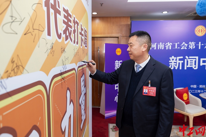 河南省工会十六大代表，平顶山市鲁山县总工会党组书记、副主席田海泉在打卡墙上签名。（受访者供图）